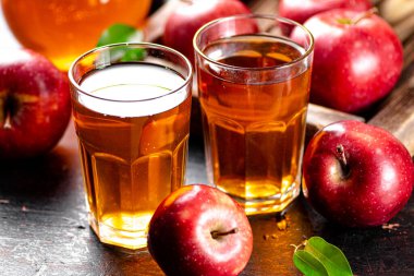 A glass of apple juice on the table. On a rustic dark background. High quality photo
