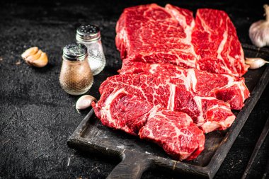 Raw beef on a cutting board. On a black background. High quality photo