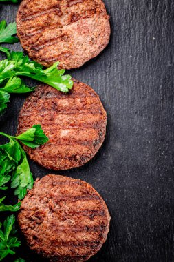 Juicy grilled burger on the table. On a black background. High quality photo