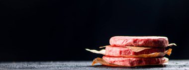 Pile raw burger on the table. On a black background. High quality photo