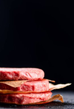 Pile raw burger on the table. On a black background. High quality photo
