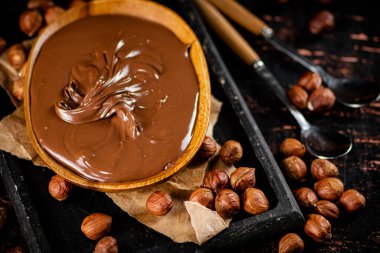 A plate of hazelnut butter on a cutting board. Against a dark background. High quality photo