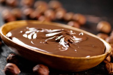 Hazelnut butter with peeled hazelnuts on the table. On a rustic dark background. High quality photo