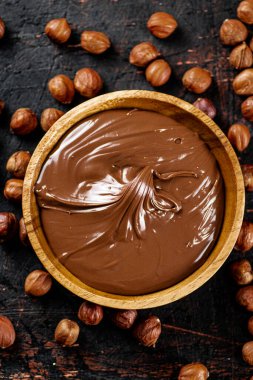 Hazelnut butter with peeled hazelnuts on the table. On a rustic dark background. High quality photo