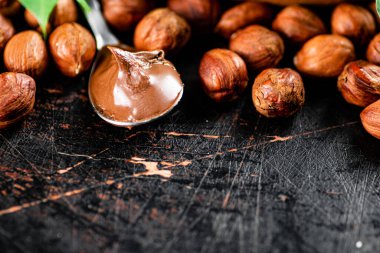Hazelnut butter in a spoon on the table. On a rustic dark background. High quality photo