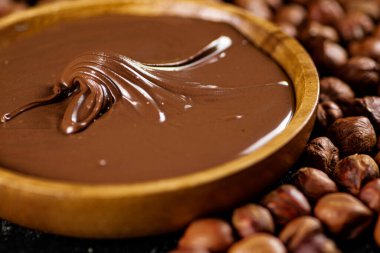 Hazelnut butter on a wooden plate with peeled hazelnuts. High quality photo