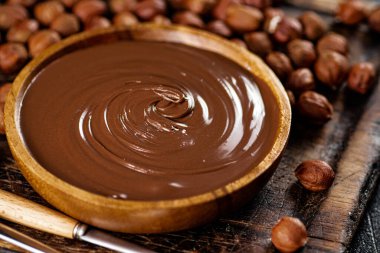 Hazelnut butter in a plate on a cutting board. Against a dark background. High quality photo