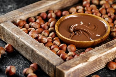 Hazelnut butter on a wooden tray. On a black background. High quality photo