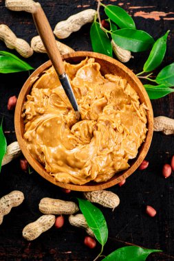 Peanut butter on a plate with a spoon. Against a dark background. High quality photo