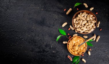 Peanut butter in a wooden plate. On a black background. High quality photo