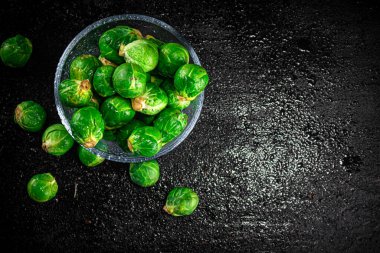 Fresh Brussels cabbage in a glass bowl. On a black background. High quality photo