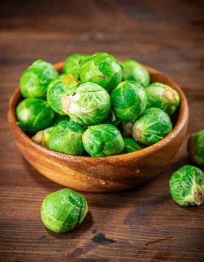 Brussels cabbage in a bowl on the table. On a wooden background. High quality photo