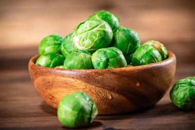 Brussels cabbage in a bowl on the table. On a wooden background. High quality photo