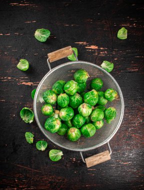 Brussels sprouts in a colander. Against a dark background. High quality photo