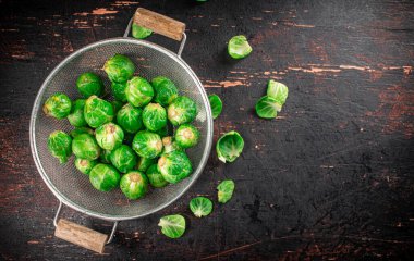 Brussels sprouts in a colander. Against a dark background. High quality photo