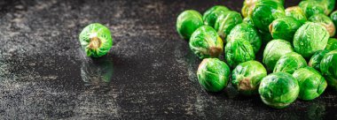 A pile of Brussels cabbage on the table. On a black background. High quality photo