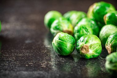 A pile of Brussels cabbage on the table. On a black background. High quality photo