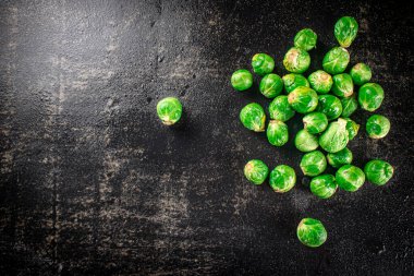 A pile of Brussels cabbage on the table. On a black background. High quality photo