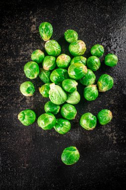 A pile of Brussels cabbage on the table. On a black background. High quality photo