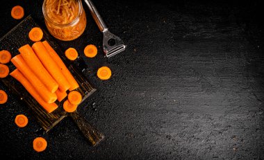 Fresh and canned carrots on a cutting board. On a black background. High quality photo