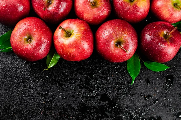 Ripe red apples with foliage. On a black background. High quality photo