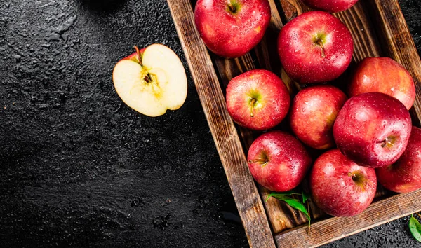 Ripe red apples on a wooden tray. On a black background. High quality photo