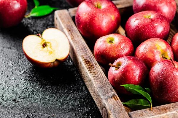 Ripe red apples on a wooden tray. On a black background. High quality photo