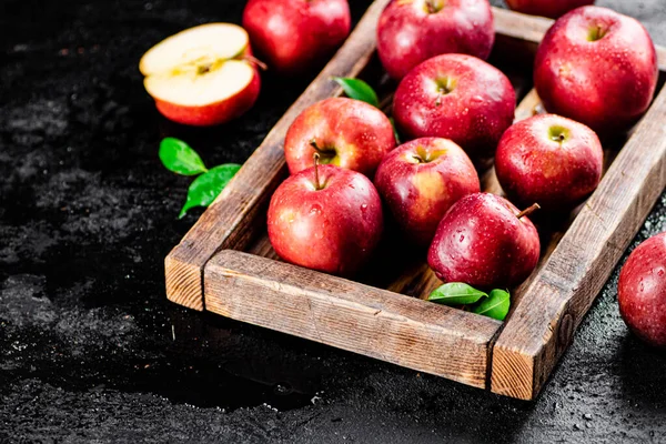 stock image Ripe red apples on a wooden tray. On a black background. High quality photo