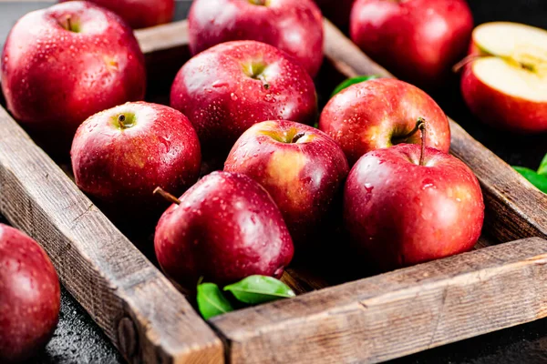 Ripe red apples on a wooden tray. On a black background. High quality photo