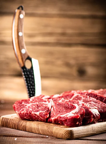 ナイフでまな板の上に生の牛肉 木製の背景に 高品質の写真 — ストック写真