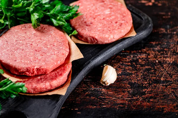 stock image Raw burger with parsley. Against a dark background. High quality photo