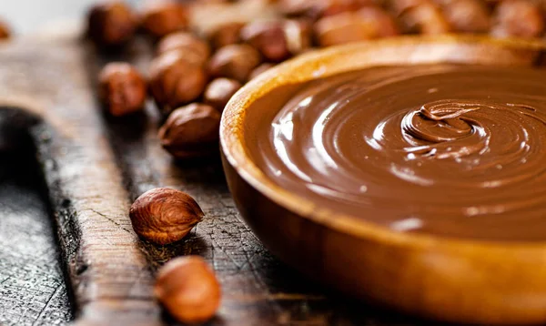 Hazelnut butter in a plate on a cutting board. Against a dark background. High quality photo