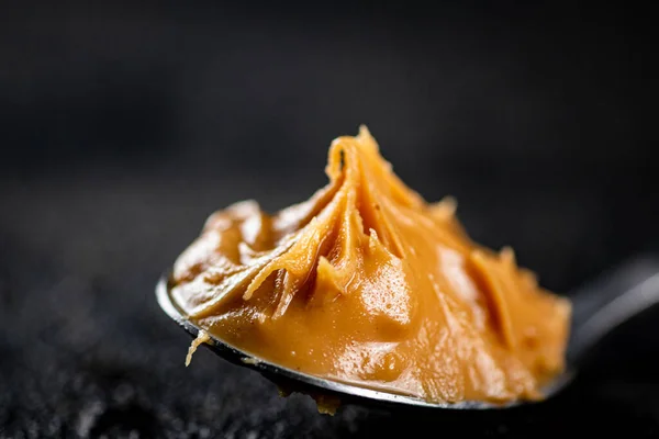 Spoonful Full Peanut Butter Black Background High Quality Photo — Stockfoto