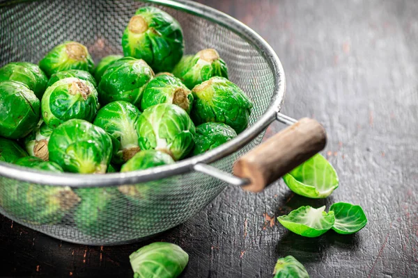 Brussels sprouts in a colander. Against a dark background. High quality photo