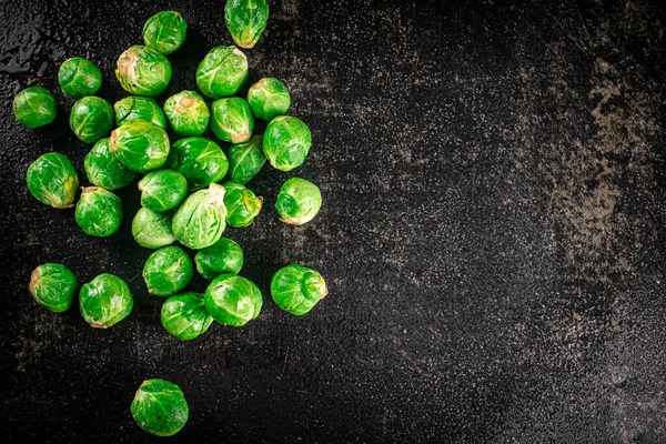 A pile of Brussels cabbage on the table. On a black background. High quality photo
