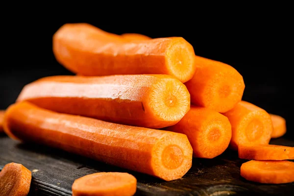 Fresh carrots on a cutting board. On a black background. High quality photo