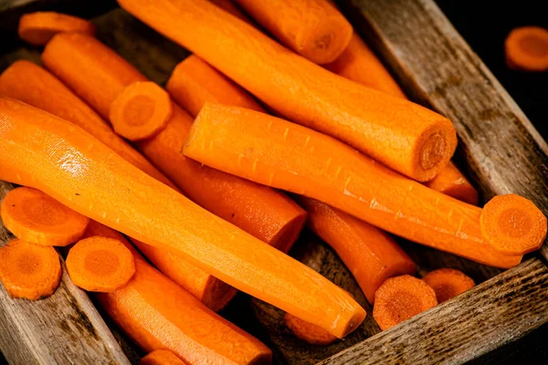 Fresh carrots on a wooden tray. On a black background. High quality photo