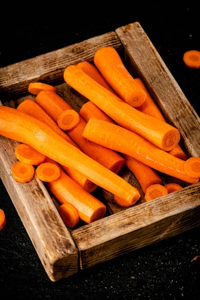 Fresh carrots on a wooden tray. On a black background. High quality photo