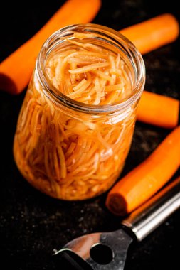 Canned carrots in a glass jar. On a black background. High quality photo