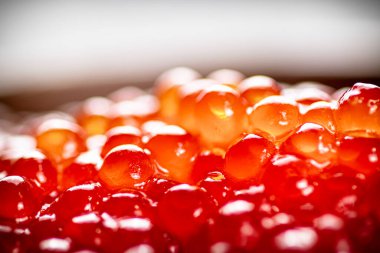 Grains of delicious red caviar. Macro background. Red caviar texture. High quality photo