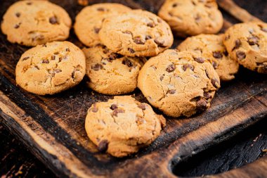 Fresh cookies with pieces of milk chocolate. Against a dark background. High quality photo