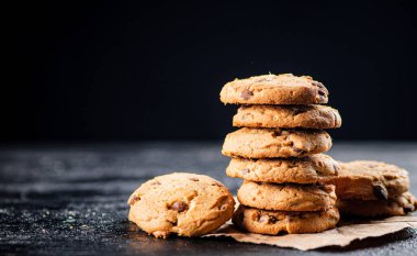 A pile of milk chocolate cookies. On a black background. High quality photo