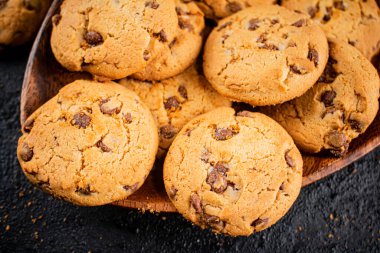 Delicious cookies with pieces of milk chocolate on a plate. On a black background. High quality photo