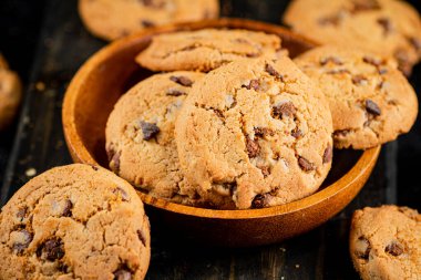 Delicious cookies with pieces of milk chocolate on a plate. On a black background. High quality photo
