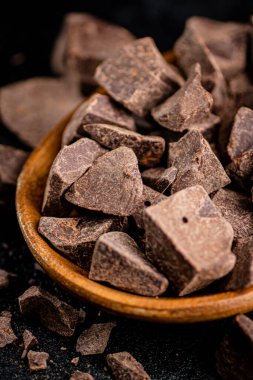 Pieces of milk chocolate on a plate. On a black background. High quality photo