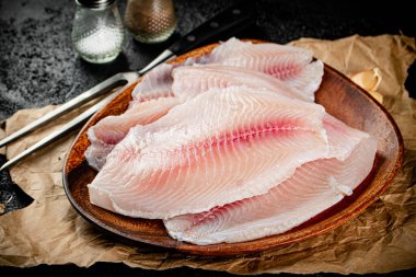 Fresh fish fillet on a wooden plate. On a black background. High quality photo