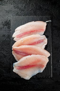 Raw fish fillet on a stone board. On a black background. High quality photo