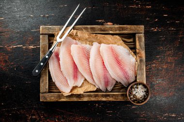 Fresh fish fillet on the tray. On a rustic dark background. High quality photo