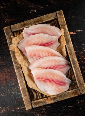 Fresh fish fillet on the tray. On a rustic dark background. High quality photo