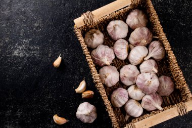 Fresh garlic in a basket. On a black background. Top view. High quality photo